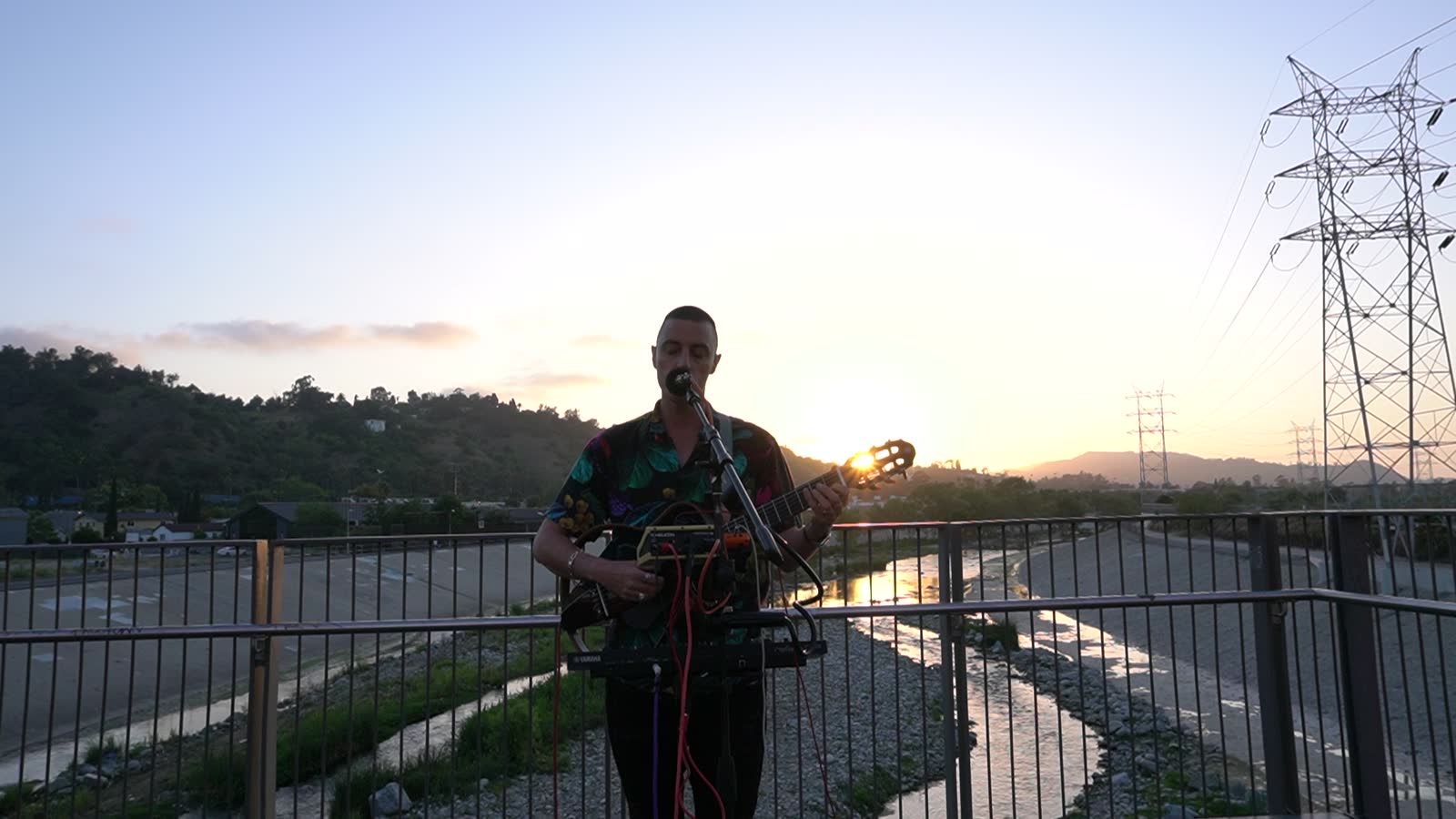 Last light on the horizon, the artist now lit, floral shirt, keyboard and guitar.